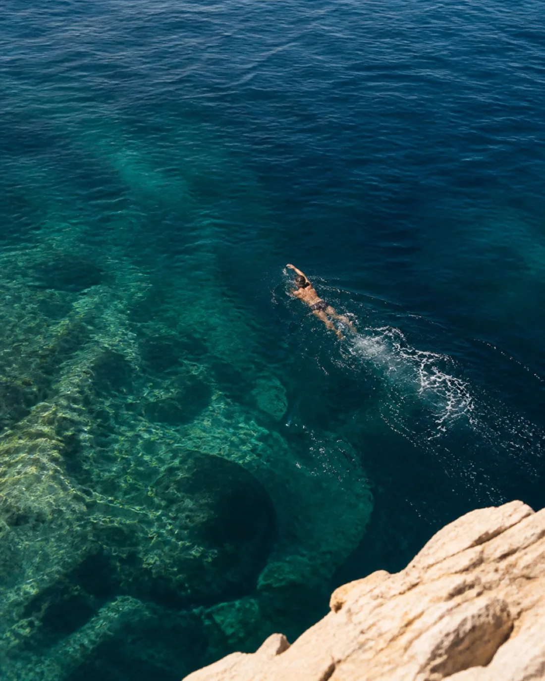 Swimmer in clear blue ocean water